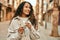 Young latin woman smiling happy counting colombia pesos banknotes at the city