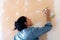 Young latin woman smooths a plastering indoor wall