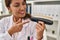 Young latin woman wearing dentist uniform holding whitening test at clinic