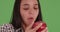 Young Latina eating an apple on green screen