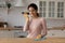 Young latina female cleaning modern kitchen hold phone use loudspeaker
