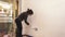 Young lating woman painting a wall in her apartment