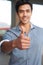 Young latino businessman holding thumbsup sign