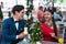 Young Latino couple in elegant dresses sitting outside drinking a refreshing drink and sharing