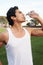 Young latino male athlete drinking water