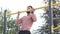 Young latino man in black pants doing exercises in a calisthenics