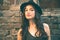 Young latino woman portrait with hat in front old house summer d