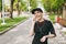 Young laughing athletic beautiful brunette girl in black uniform and cap with headphones listening music, keeping hand