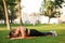 Young laughing plus size woman in sporty top and leggings trying stand in plank on orange yoga mat while spending time