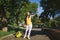 Young laughing traveler tourist woman in hat with suitcase waving hand for greeting meeting friend walk in city outdoor