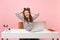 Young laughing woman clinging to hair, head finish working complete project with pc laptop while sitting at office