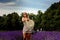 Young lavender bushes, cheerful and happy woman walks in a lavender field, fragrant flowering lavender bushes