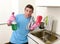 Young lazy house cleaner man washing and cleaning the kitchen wi