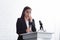 young lecturer suffering from speech anxiety standing on podium tribune with glass of water.