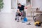 Young leg injured contractor in wheel-chair cleaning the house