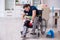 Young leg injured contractor in wheel-chair cleaning the house