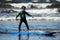 Young little boy on beach taking surfing lessons