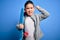 Young little boy kid skateboarder holding modern skateboard over blue isolated background annoyed and frustrated shouting with