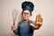 Young little caucasian cook kid wearing chef uniform and hat using manual whisk with open hand doing stop sign with serious and