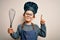 Young little caucasian cook kid wearing chef uniform and hat using manual whisk surprised with an idea or question pointing finger