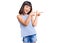 Young little girl with bang wearing casual clothes smiling and looking at the camera pointing with two hands and fingers to the