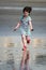 Young little girl on beach playing in the surf