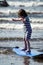 Young little girl on beach taking surfing lessons