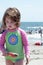 Young little girl playing with the sand and building sandcastle at the beach near the sea.