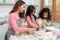 Young little girl standing at counter baking bakery in the modern kitchen at home. Happy smiling parents enjoy weekend. Child and