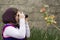 Young Little Girl Is Taking Photograph by an Analogue Camera Strapped on Her Neck in Flower Garden