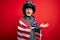 Young little patriotic kid wearing united states of america flag and motorcycle helmet on 4th of July very happy and excited,