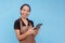 A young and lively asian female waitress or barista taking an order on her tablet while smiling.