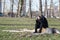 Young lonely depressed and anxious man sitting alone in the park on the wooden stump disappointed in his life crying and thinking