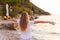 Young long hair blonde facing the sunrise at the sea