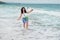 A young long-haired girl stands among the waves in the sea. white sea foam on the shore of the Black Sea in Bulgaria