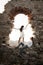 Young in love couple sitting inside brick archway of old building ruin