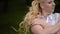 Young lovely blonde girl posing in a park in summer