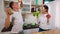 Young lovely couple dancing in the kitchen with window. Asian woman and Caucasian man singing with vegetables and