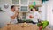 Young lovely couple dancing in the kitchen with window. Asian woman and Caucasian man singing with vegetables and