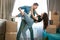 Young lovely couple man and woman looking happy dancing with passion while unpacking boxes , moving process