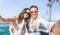 Young lover couple taking selfie on sailing boat tour around the world - Love concept at jubilee party cruise on luxury sailboat