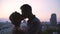 Young lovers tenderly enjoying each other against backdrop of beautiful sunset