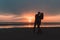 Young loving couple gently kisses at sunset on the seashore in autumn.