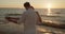 Young loving couple have fun slowly dancing on the beach at sunset