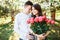 Young loving couple in love, girl holding flowers, happy and enjoy the beautiful nature, advertising, and utsava text