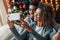 Young loving couple making selfie with Christmas tree