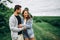 Young loving couple, woman and man, gently hugging with eyes closed on the background of green field. Love Story