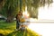 A young loving family walks by the lake with a stroller. Smiling parents couple with baby pram in autumn park. Love, parenthood, f