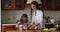 Young loving mother teach little daughter cooking vegetables salad