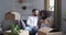 Young loving newlywed couple talking while sitting on sofa while moving house, happy caucasian millennial man and